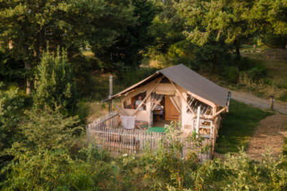 A glamping lodge secluded in a forest with a man on the decking