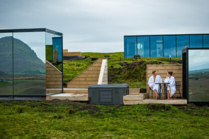 ood mirror houses with a couple relaxing outside